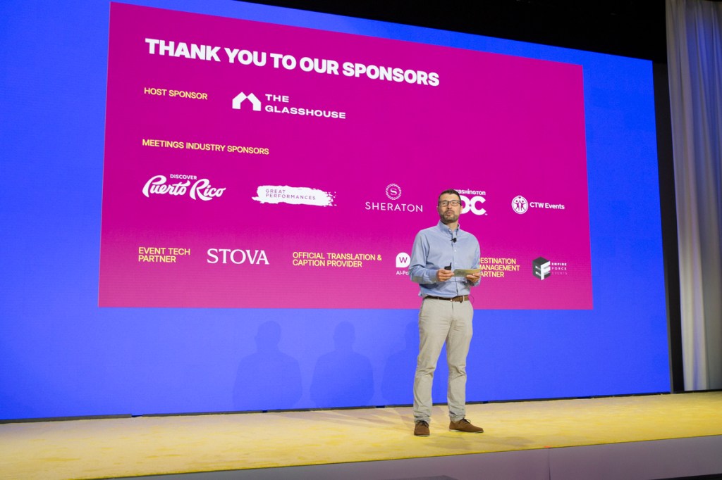 sponsor slide on stage from skift meetings forum